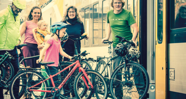 Familie mit Fahrrädern vor Regionalzug